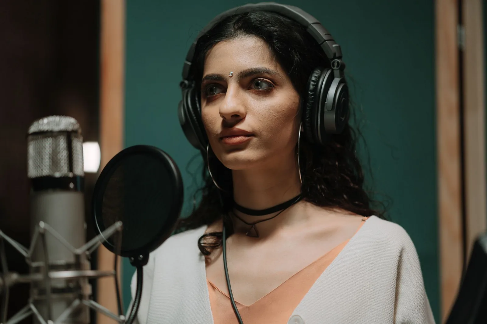 Professional singer applying vocal technique in a recording studio.